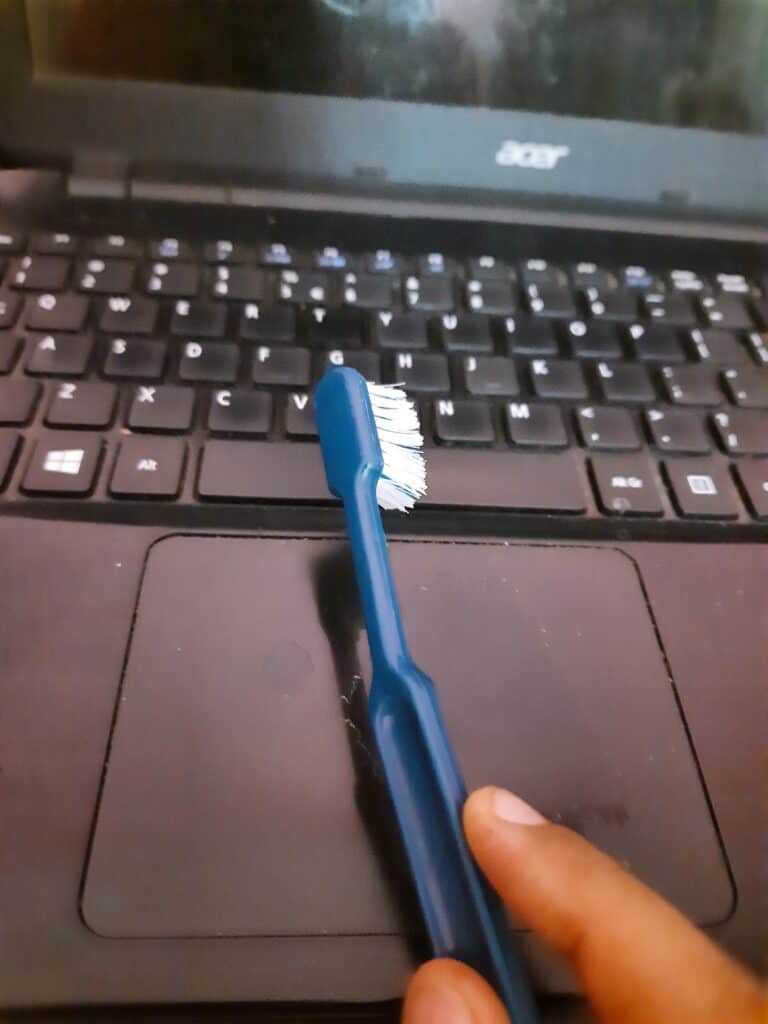 Cleaning Dusty Laptop with an Old Toothbrush