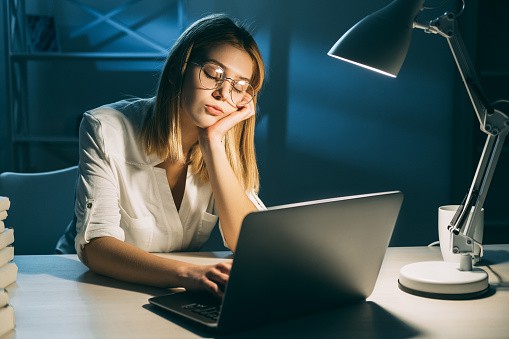 A woman is dozing off while at work